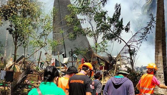 Los rescatistas llegan mientras el humo sale de los restos de un avión de transporte C-130 de la Fuerza Aérea de Filipinas después de que se estrellara cerca del aeropuerto en la ciudad de Jolo. (Foto: AFP).