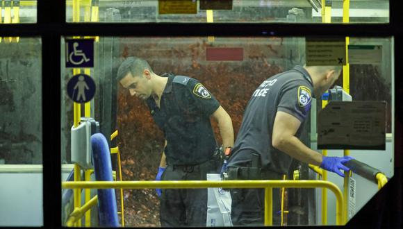 Policías de Israel inspeccionan un autobús después de un ataque en las afueras de la Ciudad Vieja de Jerusalén, el 14 de agosto de 2022. (AHMAD GHARABLI / AFP).