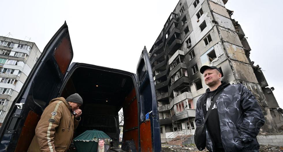 Un hombre llora frente a una minivan con el ataúd de su hijo, quien murió en el edificio cercano luego de un ataque aéreo ruso en la región de Kiev, Ucrania, el 21 de abril de 2022. (Serguéi SUPINSKY / AFP).