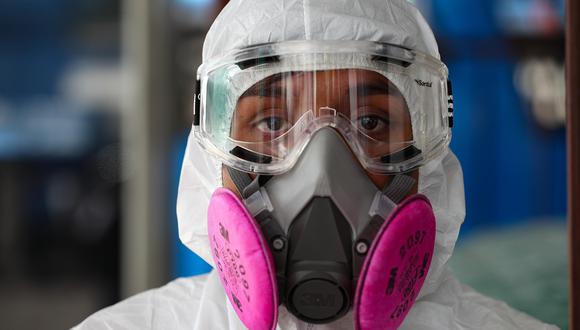 Una persona que trabaja  para el municipio de Quito, capital de Ecuador, realiza la desinfección de varias unidades de transporte de pasajeros para combatir el coronavirus. (EFE/José Jácome).