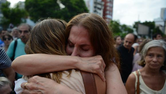 Mujeres se abrazan durante una manifestación en la ex Escuela de Mecánica de la Armada, el centro clandestino de detención más emblemático de Argentina, el 9 de enero de 2016. (Foto de EITAN ABRAMOVICH / AFP)