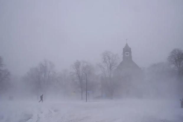 Un peatón solitario con raquetas de nieve cruza Colonial Circle cerca de la Iglesia Episcopal St. John's Grace en Buffalo, Nueva York, el sábado 24 de diciembre de 2022. (Derek Gee/The Buffalo News vía AP).