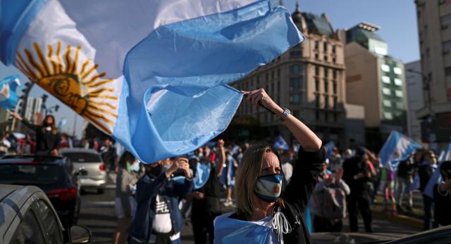 Una manifestante ondea una bandera argentina mientras participa en una protesta contra el gobierno nacional de Argentina en medio del brote de la enfermedad por coronavirus (COVID-19), en el obelisco de Buenos Aires, Argentina. (REUTERS / Agustin Marcarian).