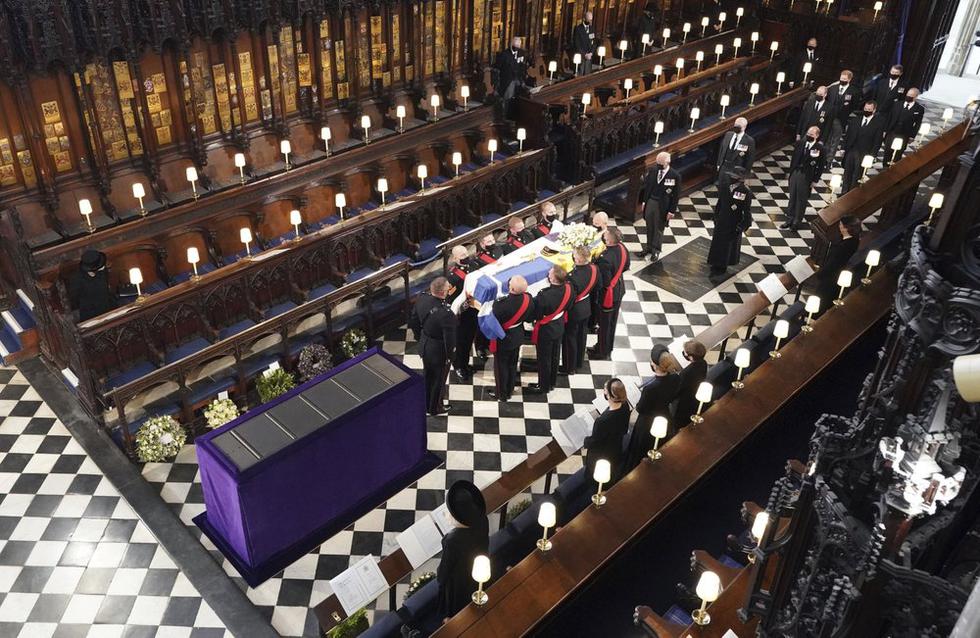 La reina Isabel de Gran Bretaña observa cómo los portadores del féretro llevan el ataúd del duque de Edimburgo durante su funeral en la Capilla de San Jorge en el Castillo de Windsor. (Dominic Lipinski / Pool vía AP).