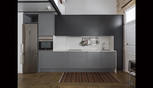En la cocina, para crear contraste, se utilizó muebles de color oscuro y electrodomésticos de acero inoxidable. (Foto: Ambau Taller d'Arquitectes)