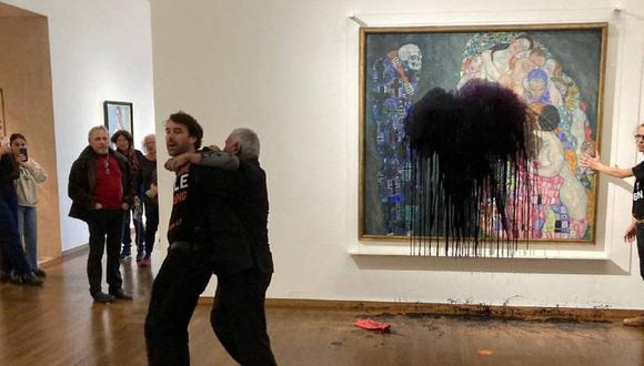 Los activistas climáticos del grupo "Última generación" vertiendo un líquido negro sobre la pintura "Muerte y vida" del artista austriaco Gustav Klimt en el Museo Leopold en Viena, Austria. . (Foto de HANDOUT / LETZTE GENERATION OSTERREICH / AFP)