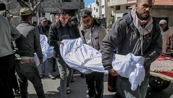 Hombres cargan los cuerpos de las personas que murieron cuando las fuerzas israelíes abrieron fuego contra una multitud que estaba en un punto de distribución de ayuda en la ciudad de Gaza el 29 de febrero de 2024. (Foto de AFP).