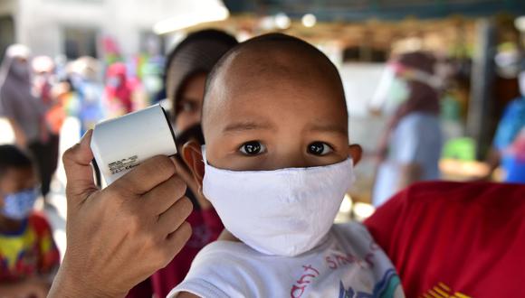 Toman la temperatura de un niño en Tailandia en medio de la pandemia del coronavirus, el 17 de abril de 2020.  Foto: AFP / Madaree TOHLALA