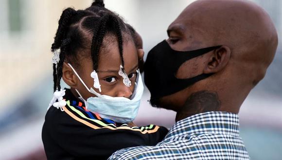 Una padre y su hija que usan mascarillas esperan para hacerse una prueba de coronavirus COVID-19 en un clínica móvil  en Los Ángeles, California, Estados Unidos. (EFE / EPA / ETIENNE LAURENT).