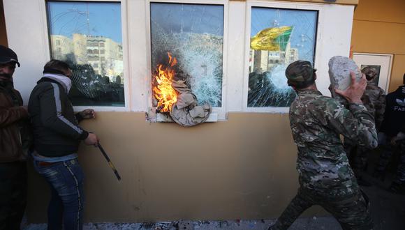 Miembros de una milicia chiita rompen el vidrio a prueba de balas de las ventanas de la embajada de Estados Unidos en Bagdad. (AFP).