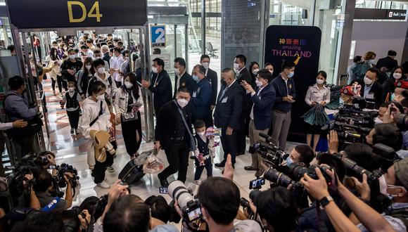 Los miembros de los medios registran a los viajeros de un vuelo de Xiamen Airlines que llegaron al aeropuerto de Suvarnabhumi en Bangkok el 9 de enero de 2023, cuando China eliminó las restricciones de viaje de Covid-19. (Foto de Jack TAYLOR / AFP)