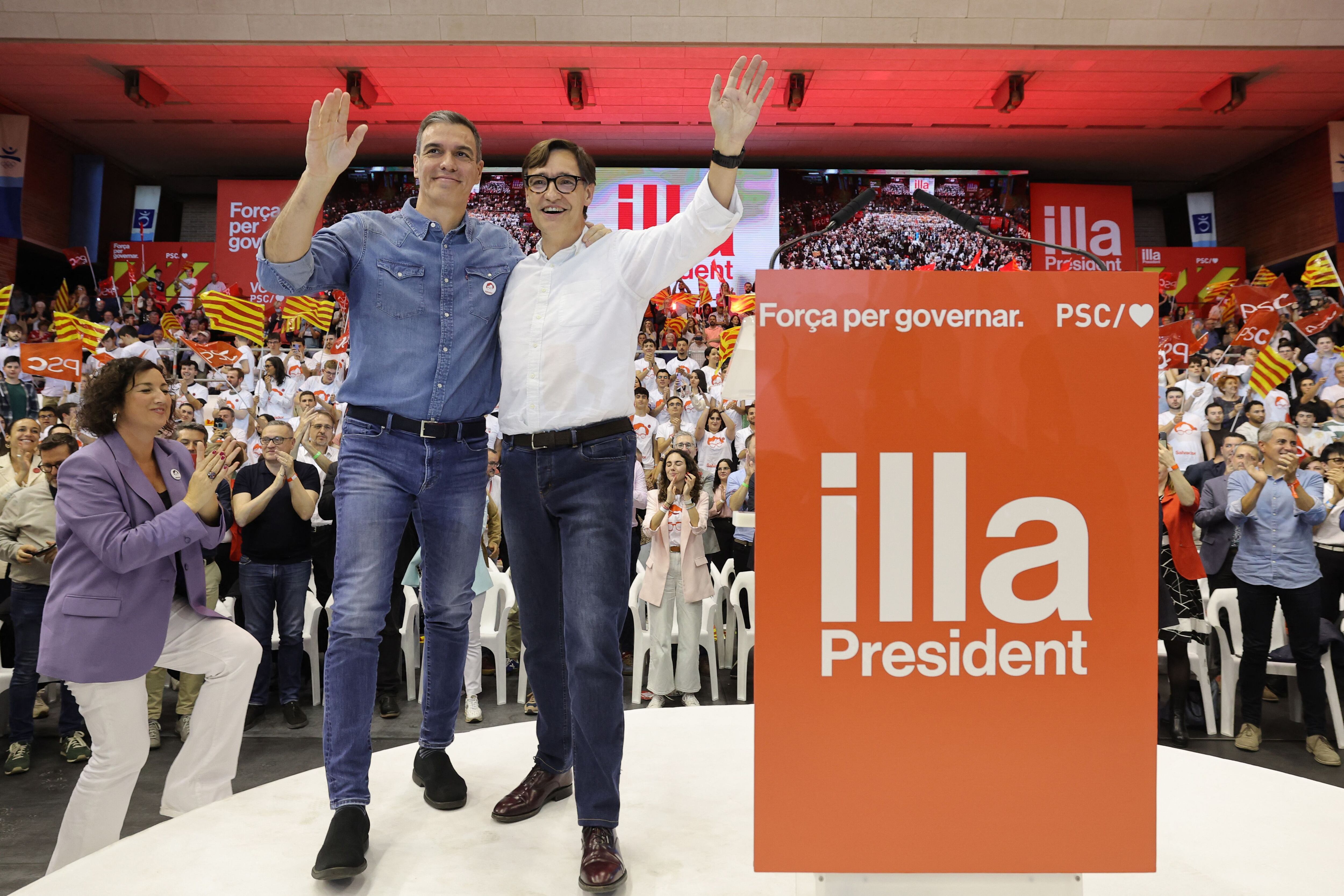 Pedro Sánchez y el candidato Salvador Illa, saludan desde el escenario durante el mitin de clausura del Partido Socialista Catalán. (Foto de LLUIS GENE / AFP).