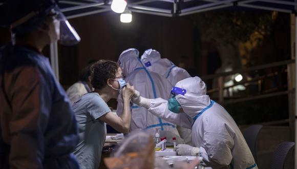 Los trabajadores de la salud realizan pruebas de hisopado de covid-19 a los residentes del distrito de Xuhui en Shanghái, China. transmisión.