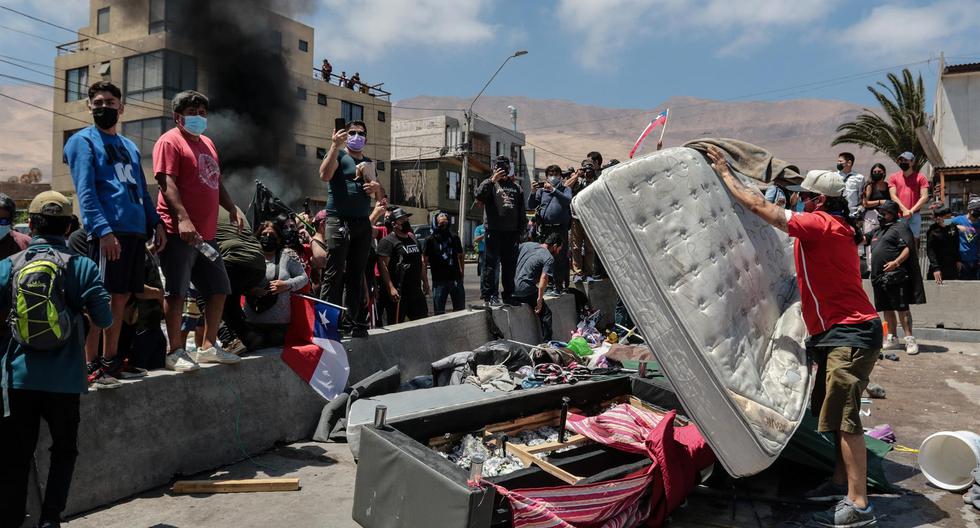 Grupo de personas queman carpas que eran utilizadas por extranjeros para pernoctar en plazas y playas en Iquique, Chile. (EFE/ Johan Berna).