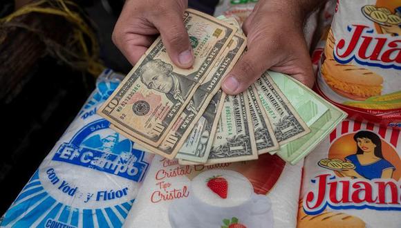Un vendedor informal muestra billetes de dólar en su negocio de venta de comida, el 5 de febrero en Caracas, Venezuela. (EFE/ Rayner Peña R).