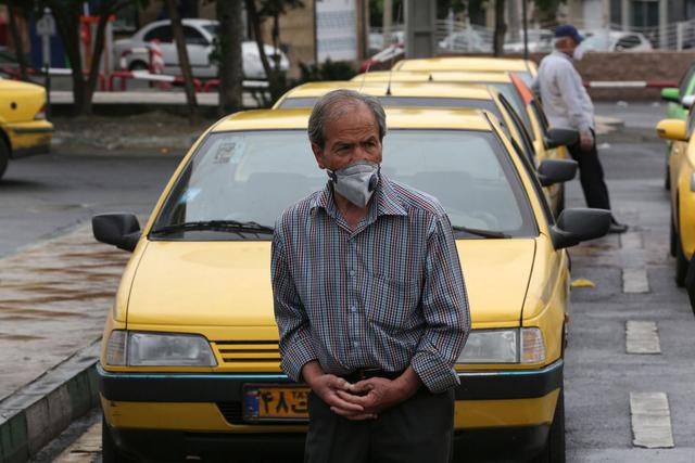 Los taxistas iraníes esperan a los pasajeros en la estación de Aryashahr, un centro de transporte en el oeste de Teherán, ya que sus servicios han estado entre los más afectados desde el brote de coronavirus del país. (Foto: AFP/Atta Kenare)