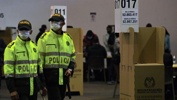 La policía hace guardia en un colegio electoral durante la segunda vuelta de las elecciones presidenciales de Colombia, el 19 de junio de 2022. (Juan BARRETO / AFP).