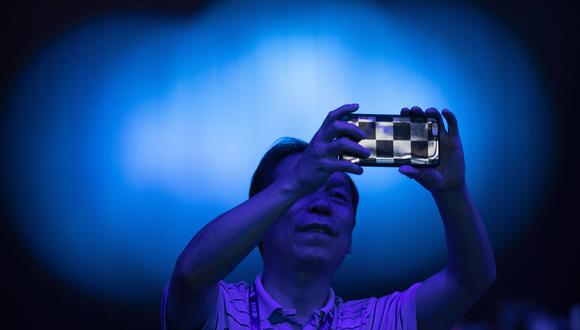 Imagen referencial. Una persona sostiene un celular en Beijing, China. AP