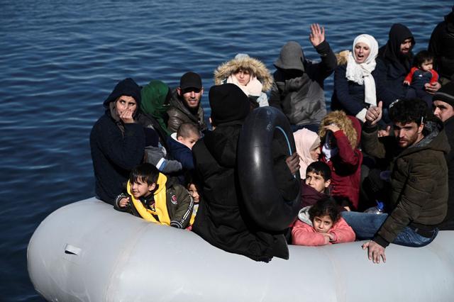 Los inmigrantes son vistos en un bote inflable mientras los residentes locales les impiden desembarcar en la isla de Lesbos. (AFP).