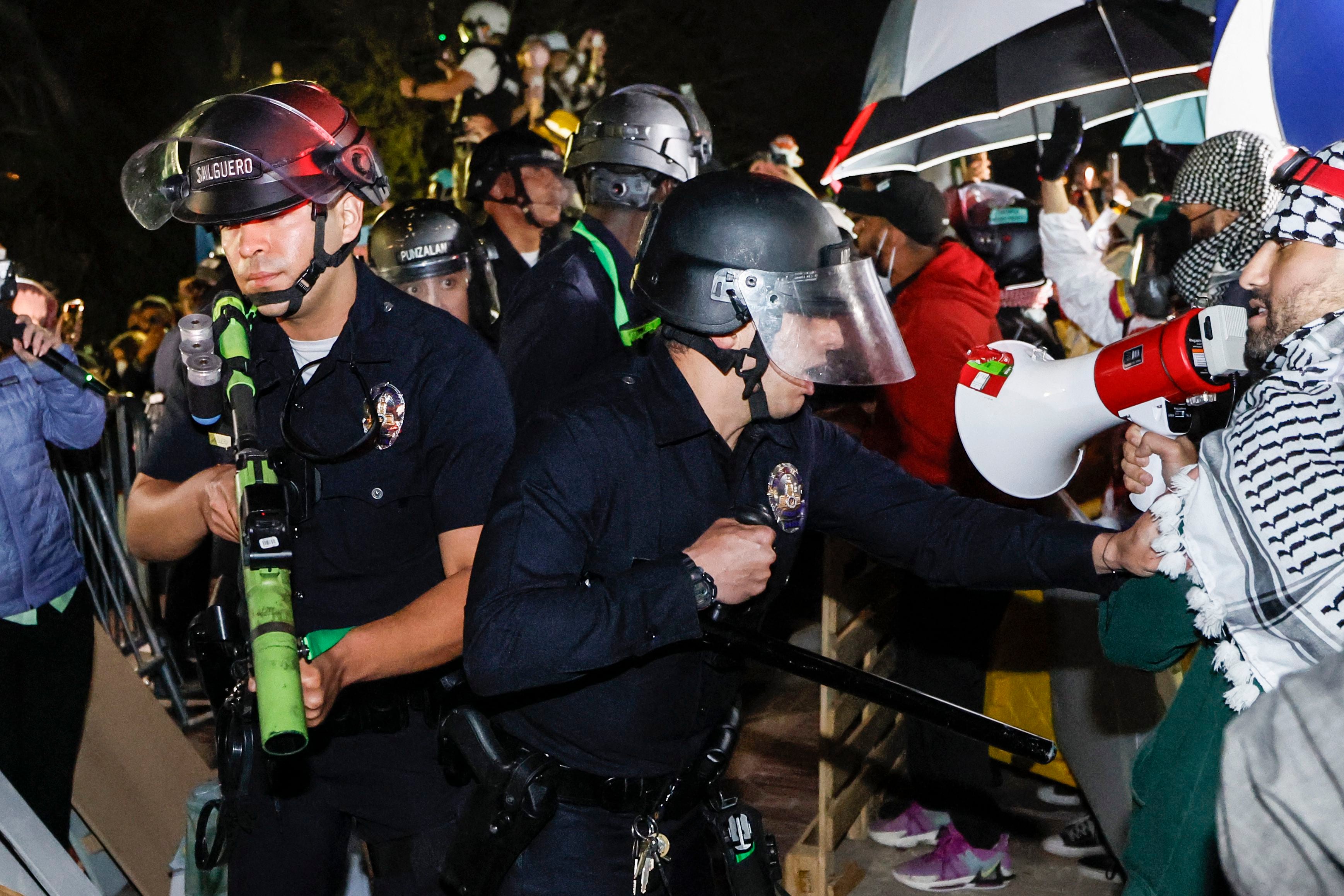 La policía reacciona mientras los estudiantes pro palestinos se mantienen firmes después de que irrumpiera en su campamento en el campus de la Universidad de California en Los Ángeles (UCLA), el 2 de mayo de 2024. (Foto de Etienne LAURENT / AFP).