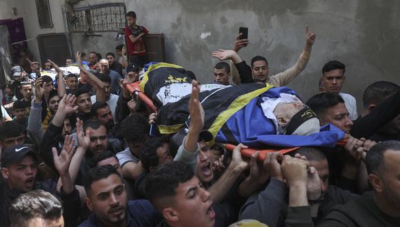 Los dolientes llevan los cuerpos del miembro del grupo Jihad Islámico Palestino Jihad Ghannam y su esposa durante su funeral en Rafah, en el sur de la Franja de Gaza, el 9 de mayo de 2023, luego de su muerte en un ataque aéreo israelí antes del amanecer. (Foto de SAID KHATIB / AFP)