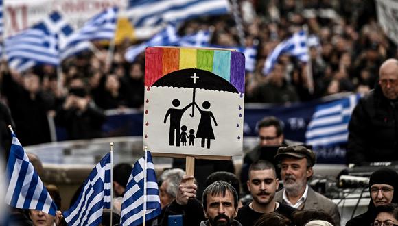 Un manifestante sostiene una pancarta durante una manifestación contra una reforma que legaliza el matrimonio y la adopción entre personas del mismo sexo en Atenas el 11 de febrero de 2024. (Foto de Aris MESSINIS / AFP)