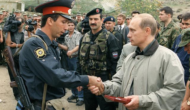 27 de agosto de 1999. El primer ministro ruso Vladimir Putin entrega un premio a un oficial de policía local en una base militar rusa en las montañas de la región de Botlikh, Daguestán. (Foto: AP/Archivo)