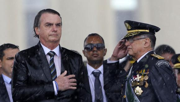 En esta foto de archivo tomada el 17 de abril de 2019, el presidente brasileño Jair Bolsonaro y el comandante del Ejército Edson Pujol están empapados de lluvia mientras asisten a una ceremonia para conmemorar el Día del Ejército. (Foto de Sergio LIMA / AFP).