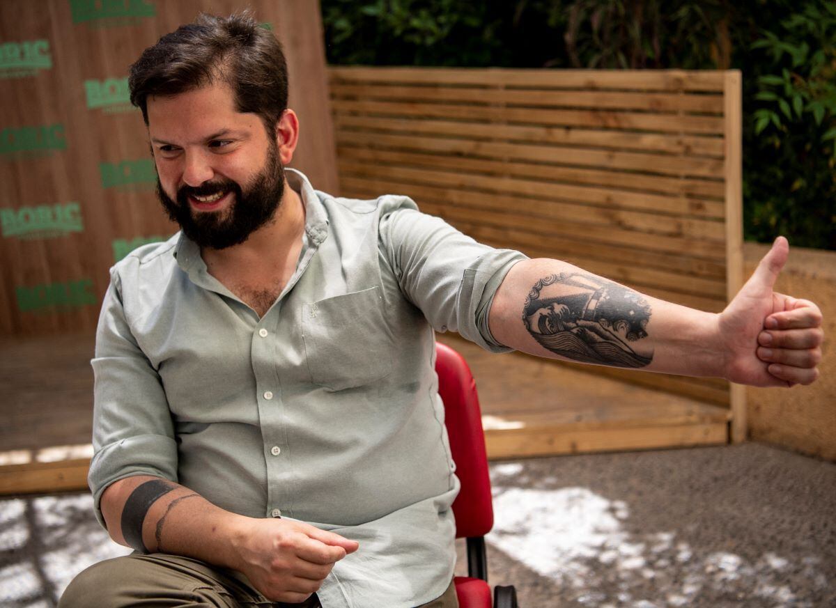 Gabriel Boric shows one of his tattoos during an interview with AFP in Santiago, on October 28, 2021. (MARTIN BERNETTI / AFP).