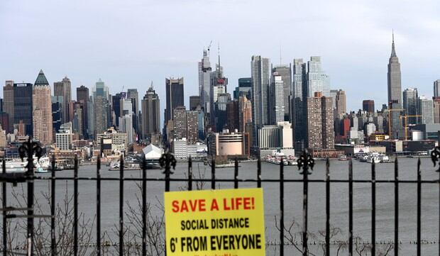 Un cartel cuelga en un parque con vistas al horizonte de Manhattan, en el que pide respetar la distancia social por el coronavirus. (Foto: AFP/Zinyange Auntony)