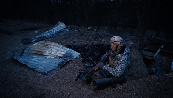 Un miembro de la unidad de voluntarios ucranianos "Aduana", de 56 años, posa junto a los escombros causados por un dron que se estrelló en una trinchera utilizada por la unidad para contrarrestar las amenazas durante las sirenas de ataque aéreo en un suburbio de Kiev el 28 de febrero de 2023. (Foto: YASUYOSHI CHIBA / AFP)