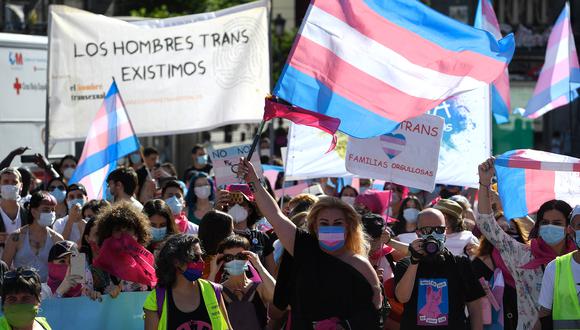 Manifestantes con mascarillas ondean banderas trans durante una manifestación que pide más derechos para los transexuales en la Puerta del Sol de Madrid el 4 de julio de 2020.