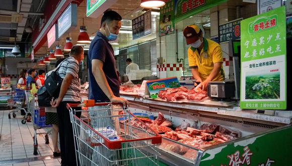 Un cliente que usa una mascarilla compra carne de cerdo en un supermercado en Beijing el 16 de junio de 2020. En China surgió el nuevo coronavirus Covid-19. (Foto de WANG ZHAO / AFP).