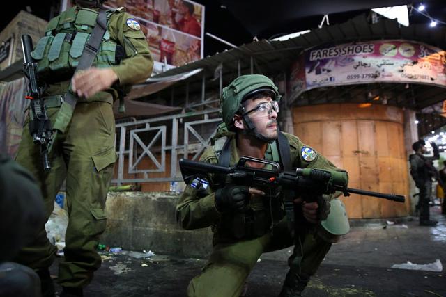 Tropas israelíes son vistas durante enfrentamientos con manifestantes palestinos en el centro de la ciudad cisjordana de Hebrón, 11 de mayo de 2021. (EFE / EPA / ABED AL HASHLAMOUN).
