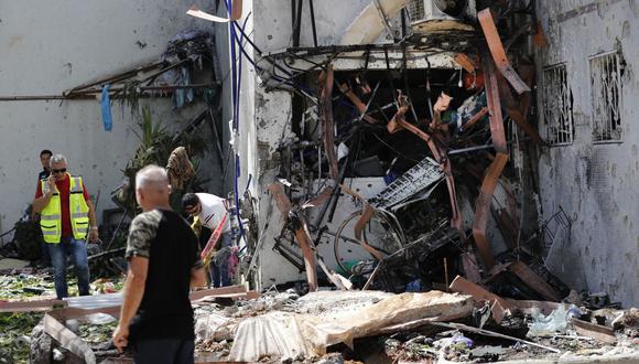 Los residentes israelíes y los equipos de rescate inspeccionan un edificio que fue impactado por un cohete lanzado desde la Franja de Gaza, en la ciudad de Ashdod, en el sur de Israel. (Foto de Ahmad GHARABLI / AFP).