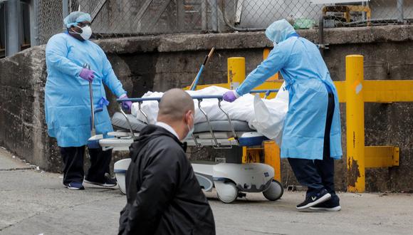 Estados Unidos superó a China en número de muertos por coronavirus. En la imagen, trabajadores de un hospital de Nueva York trasladan el cadáver de una víctima de Covid-19. (REUTERS/Brendan McDermid).