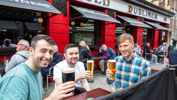 Un grupo de amigos toma cerveza en un pub reabierto en Dublín, Irlanda, el 7 de junio de 2021. (PAUL FAITH / AFP).