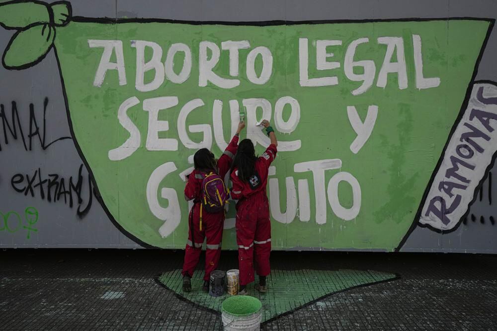 In this Sept. 28, 2021 photo, abortion rights protesters paint a mural during a Global Day of Action for access to legal, safe and free abortion, in Santiago, Chile.  (AP Photo/Esteban Felix, File)