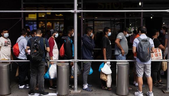 Un grupo de inmigrantes de Texas espera en fila afuera de la Terminal de Autobuses de la Autoridad Portuaria para recibir asistencia humanitaria el 10 de agosto de 2022 en Nueva York. (Foto: Yuki IWAMURA / AFP)