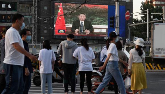Un programa de noticias muestra al presidente chino, Xi Jinping, hablando a través de un enlace de video a la Asamblea Mundial de la Salud, en una pantalla gigante al lado de una calle en Beijing. (Foto: GREG BAKER / AFP).