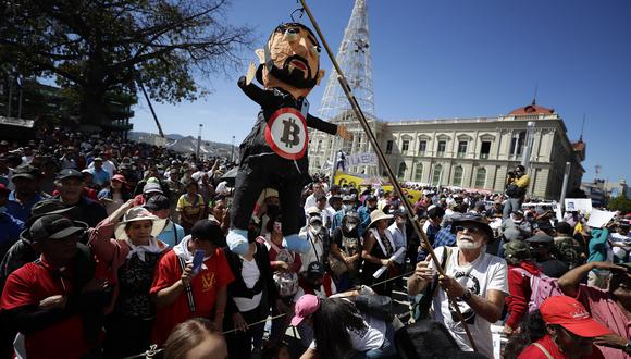 Un excombatiente guerrillero sostiene un muñeco alusivo al presidente salvadoreño, Nayib Bukele, en la plaza Gerardo Barrios.