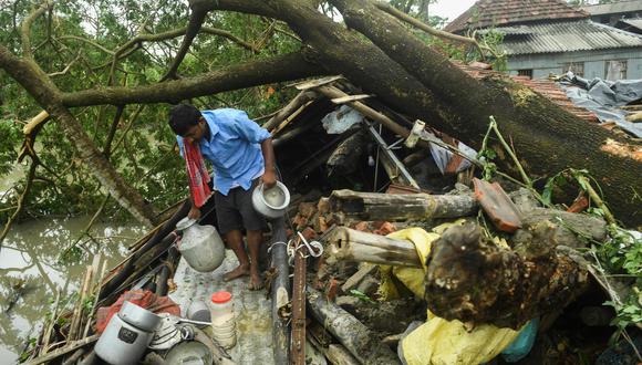 Un hombre salva objetos de su casa que fue destruida por el ciclón Amphan en Midnapore, Bengala Occidental (India). Foto: AFP / Dibyangshu SARKAR