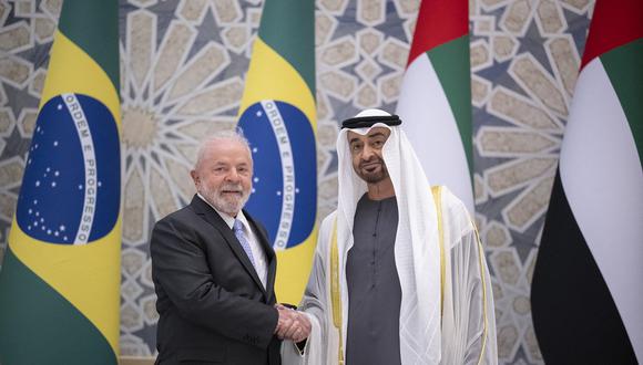 El presidente de los Emiratos Árabes Unidos, el jeque Mohamed bin Zayed al-Nahyan (D), junto al presidente de Brasil, Luiz Inacio Lula da Silva (I), en Qasr al-Watan en Abu Dhabi. (Foto de Rashed AL-MANSOORI / UAE PRESIDENTIAL COURT / AFP)