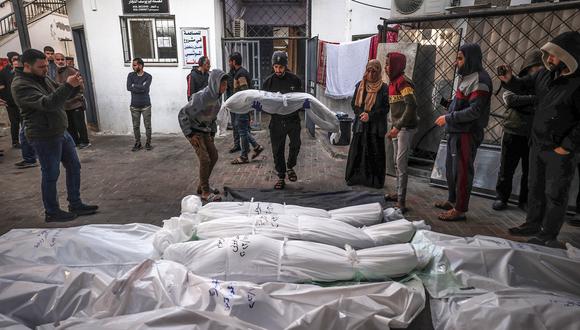 Cuerpos envueltos de personas asesinadas en Rafah durante el bombardeo israelí en la franja del sur de Gaza, se colocan fuera del Hospital Al-Najar el 29 de diciembre de 2023 (Foto de AFP)