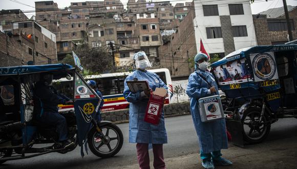 Trabajadores de la salud llegan para inocular a ancianos con dosis de la vacuna Pfizer/BioNTech contra COVID-19, a su casa del distrito El Agustino en Lima, el 28 de abril de 2021. (Foto: ERNESTO BENAVIDES / AFP)