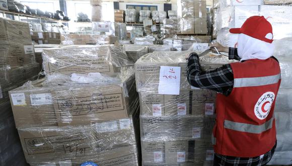 Un miembro del personal de la Sociedad de la Media Luna Roja Egipcia maneja paquetes de ayuda humanitaria con destino a los palestinos en la Franja de Gaza, en un almacén en Arish, Egipto, el 25 de octubre de 2023. EFE/EPA/KHALED ELFIQI