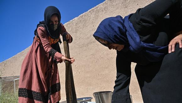 Mujeres lavan ovillos de seda recién teñida en una fábrica de seda en la provincia de Herat el 4 de agosto de 2022. (Foto de Lillian SUWANRUMPHA / AFP)