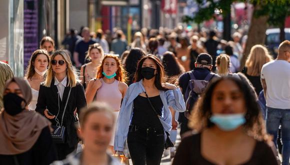 Peatones, algunos con cubiertas faciales debido al coronavirus, pasan frente a las tiendas de Oxford Street en el centro de Londres, Reino Unido, el 7 de junio de 2021. (Niklas HALLE'N / AFP).