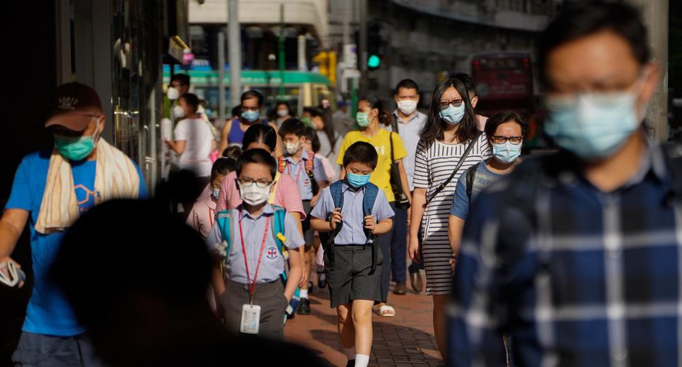 Imagen referencial. Los peatones y escolares con máscaras protectoras caminan por una acera en Hong Kong. (Roy Liu/Bloomberg).