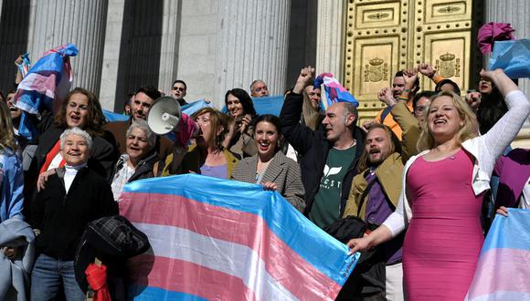 Diferentes activistas y la ministra de Igualdad de España, Irene Montero (al centro), celebran frente al Congreso español, en Madrid el 16 de febrero de 2023 después de que se votara la 'ley transgénero'. España adoptó una ley que simplifica el proceso de autoidentificación como transgénero, otros pioneros están frenando las complejidades involucradas en este tema tan sensible (Foto: OSCAR DEL POZO / AFP)